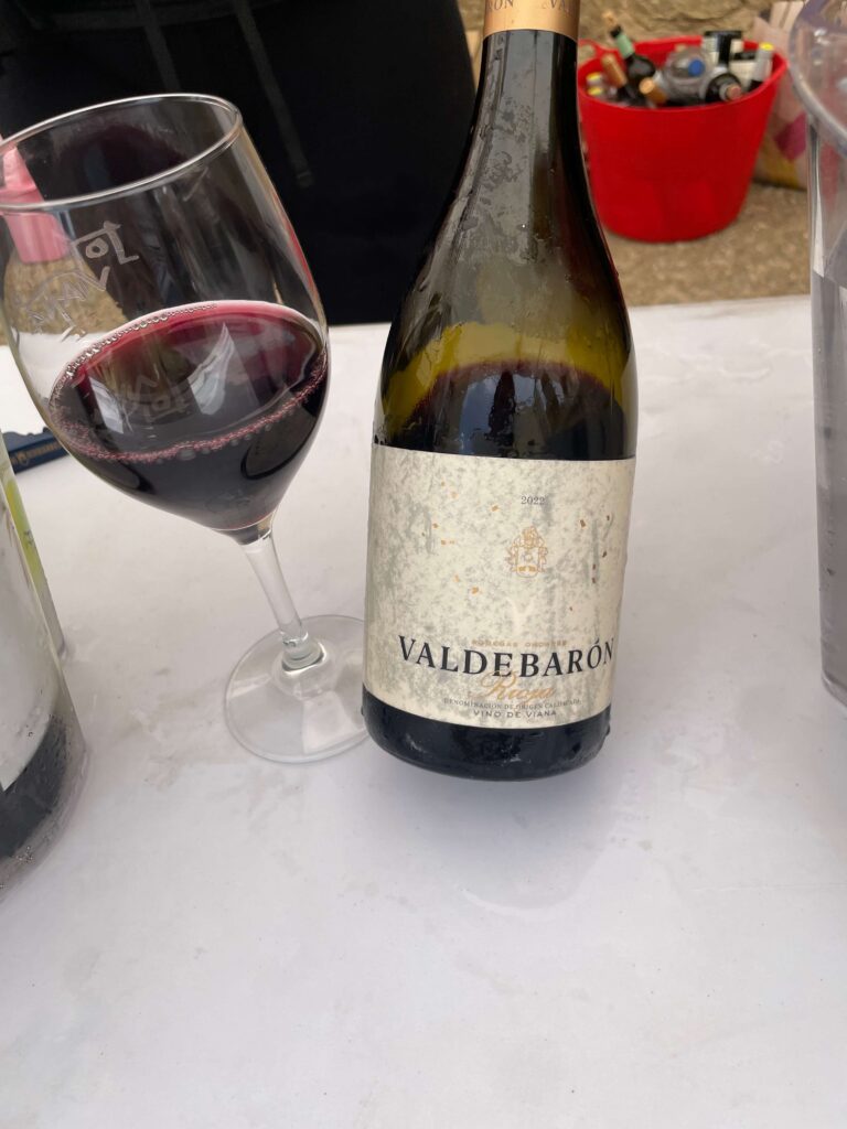 Bodegas ondarreのValdebaronの濡れたボトルとグラスに注がれたワイン