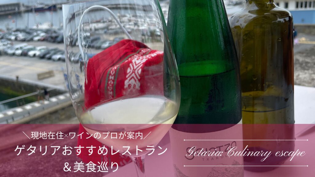 ゲタリアの港を背景に白ワインのグラスとボトルがアップになったアイキャッチ画像