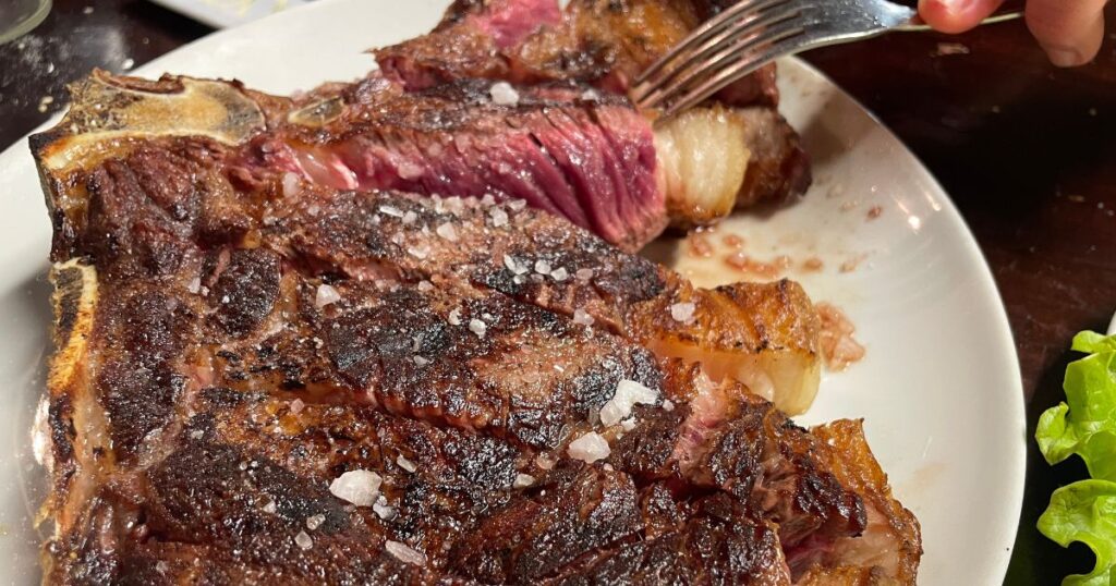 あら塩をまぶしてカットされた骨付き牛肉