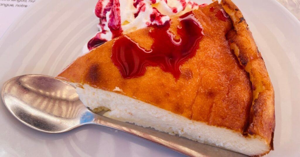 生クリームとベリーソースが添えられたベイクドチーズケーキ